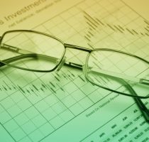 Glasses on stock market graph, financial concept